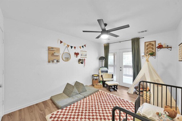 bedroom featuring access to exterior, hardwood / wood-style flooring, and ceiling fan