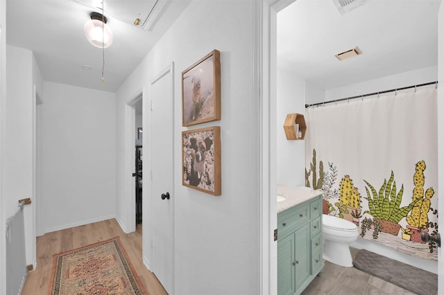 corridor with radiator heating unit and light wood-type flooring