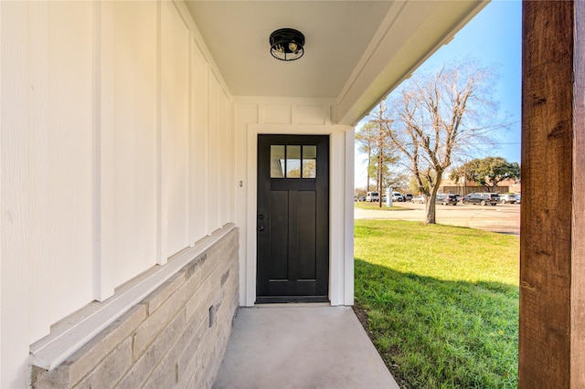 property entrance featuring a lawn