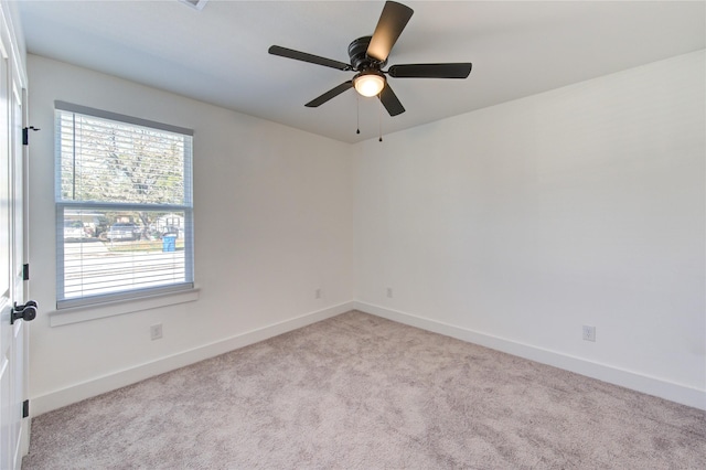 carpeted spare room featuring ceiling fan