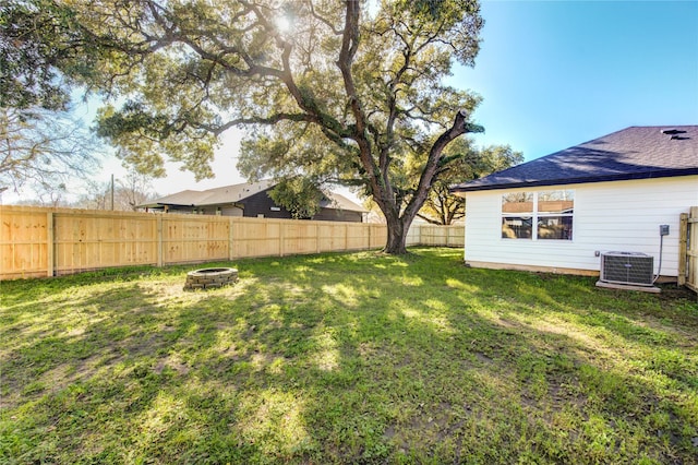 view of yard with an outdoor fire pit and central air condition unit