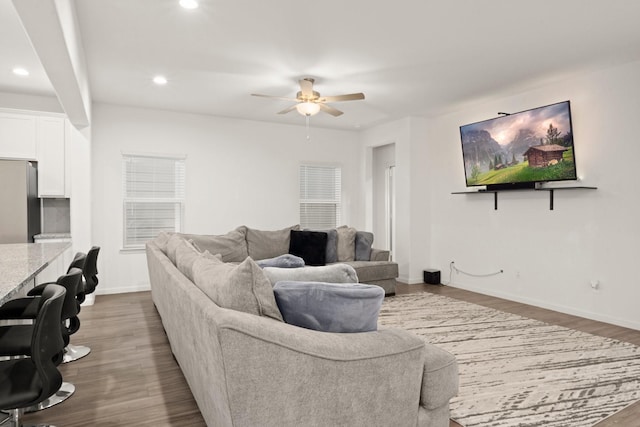 living room featuring ceiling fan and dark hardwood / wood-style flooring