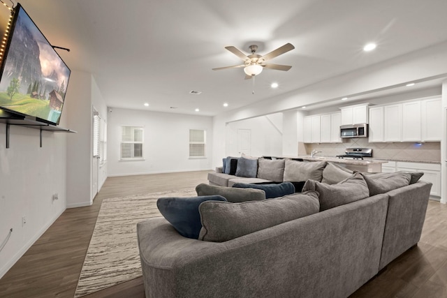 living room featuring ceiling fan and hardwood / wood-style flooring