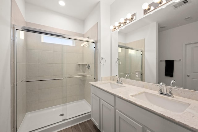 bathroom with vanity, wood-type flooring, and an enclosed shower