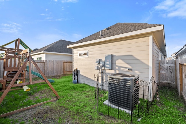 back of house featuring a yard, a playground, and cooling unit