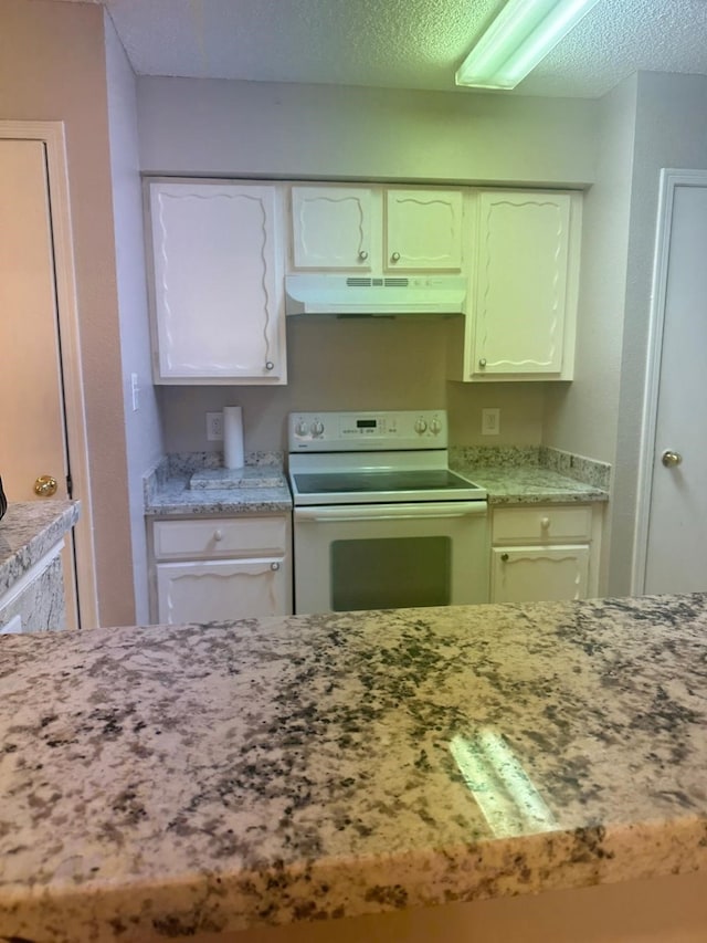 kitchen with white range with electric cooktop, white cabinetry, and a textured ceiling