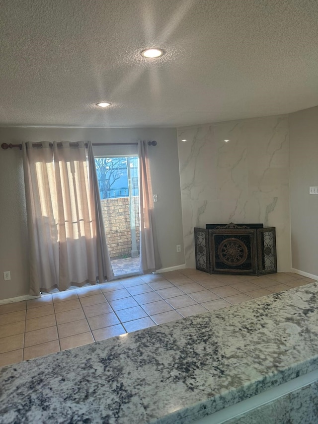 unfurnished living room featuring a textured ceiling and light tile patterned flooring