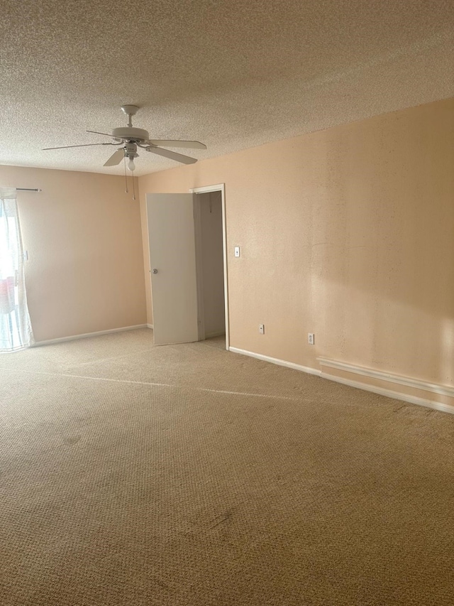 empty room featuring a textured ceiling, carpet floors, and ceiling fan