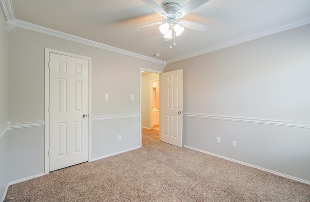 unfurnished bedroom with ceiling fan, light colored carpet, and crown molding