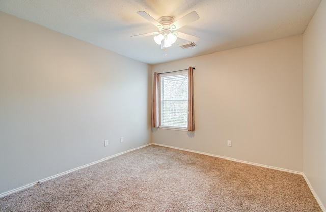 carpeted spare room with ceiling fan