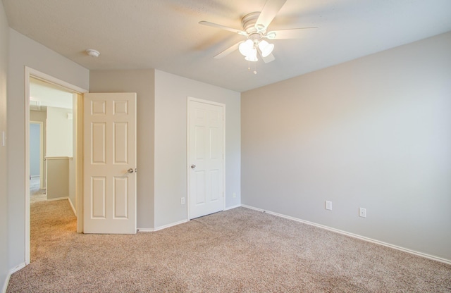 unfurnished bedroom featuring ceiling fan, light colored carpet, and a closet