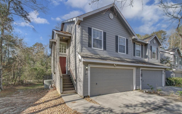 view of front of home with a garage and central air condition unit