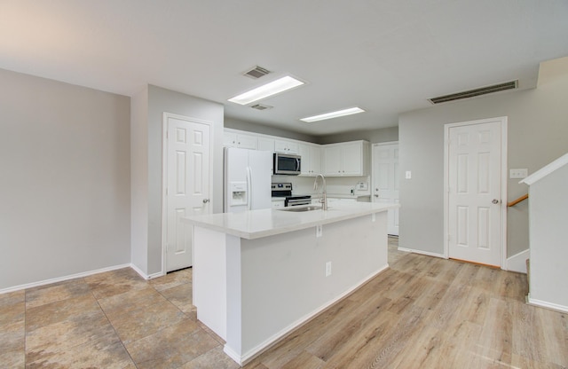 kitchen with sink, stainless steel appliances, light hardwood / wood-style flooring, an island with sink, and white cabinets