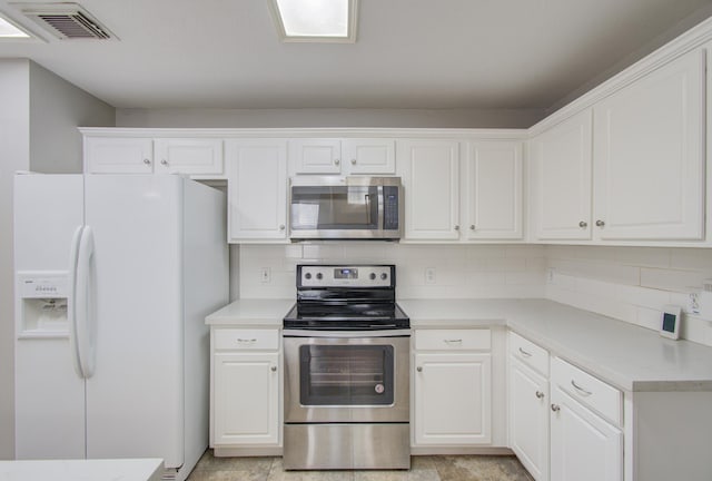 kitchen with white cabinets, backsplash, and stainless steel appliances