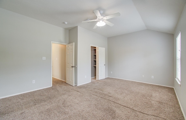 spare room featuring light carpet, ceiling fan, and lofted ceiling