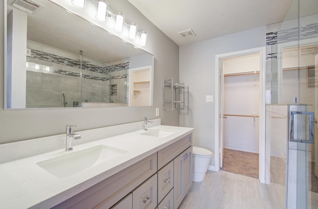 bathroom with toilet, vanity, and walk in shower