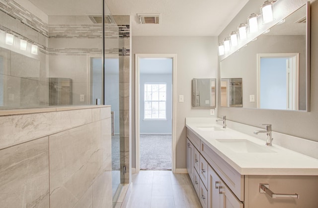 bathroom featuring tile patterned flooring, vanity, and a shower with shower door