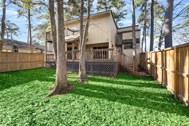 rear view of house with a lawn and a wooden deck