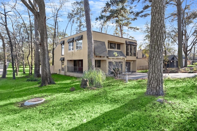 rear view of house with a lawn and a garage