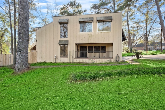 rear view of house featuring a lawn