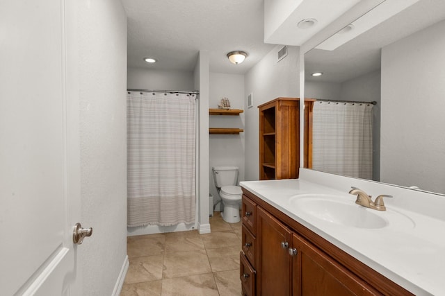 bathroom with tile patterned floors, vanity, toilet, and walk in shower