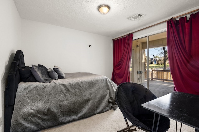 bedroom featuring carpet, a textured ceiling, and access to outside