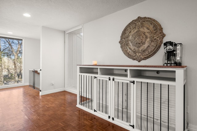 hall featuring a textured ceiling and parquet flooring