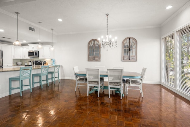 dining room featuring dark parquet flooring, a textured ceiling, an inviting chandelier, and crown molding