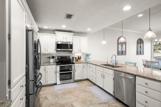 kitchen featuring white cabinetry, sink, stainless steel appliances, and decorative light fixtures