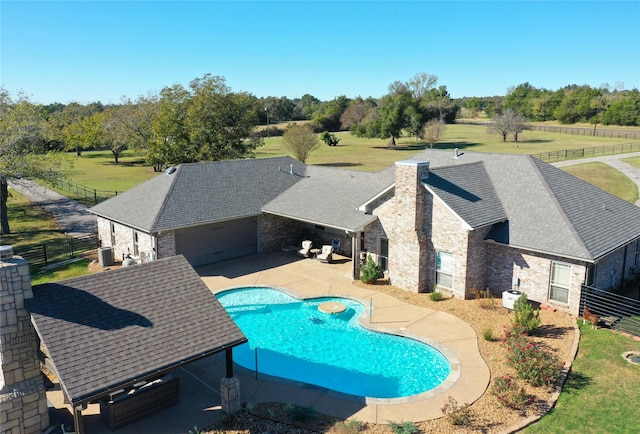 view of pool with a yard, cooling unit, and a patio