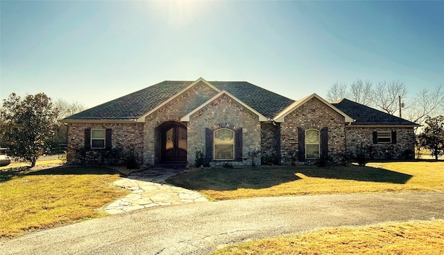 view of front of home with french doors and a front lawn