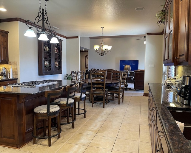 tiled dining space featuring crown molding and an inviting chandelier