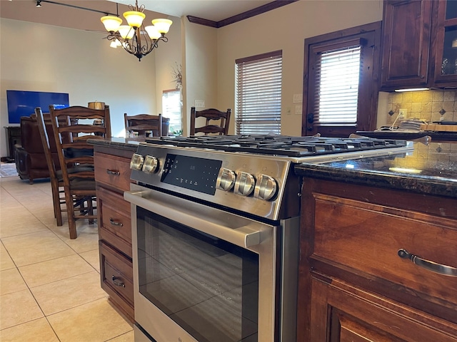 kitchen featuring stainless steel gas range oven, ornamental molding, light tile patterned floors, decorative light fixtures, and a chandelier