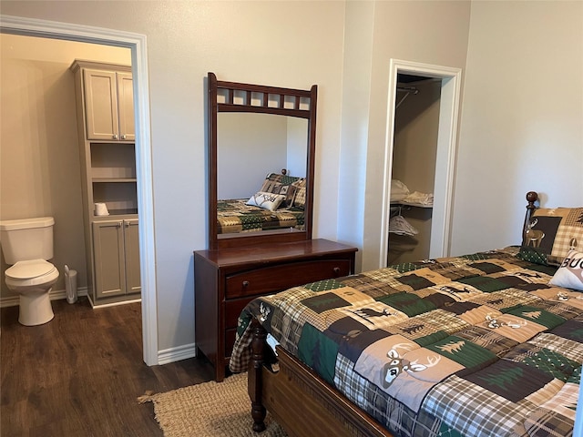 bedroom with a spacious closet, a closet, and dark wood-type flooring