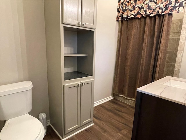 bathroom featuring built in features, vanity, hardwood / wood-style flooring, and toilet