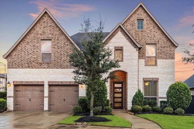 view of front of home featuring stone siding, brick siding, and driveway