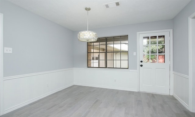 unfurnished dining area featuring light wood-type flooring