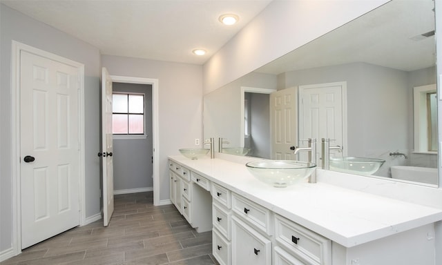 bathroom with vanity and a bath