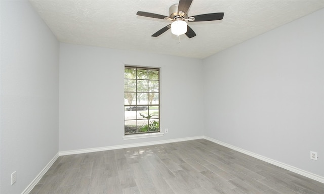 unfurnished room with ceiling fan, a textured ceiling, and light hardwood / wood-style flooring