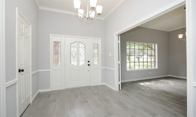 entrance foyer featuring a chandelier, light hardwood / wood-style flooring, and crown molding