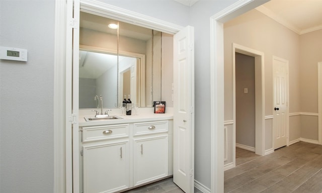 bathroom featuring hardwood / wood-style flooring, vanity, and ornamental molding