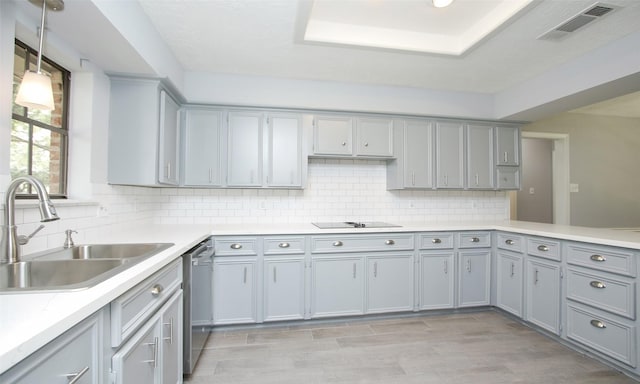 kitchen featuring dishwasher, sink, decorative light fixtures, gray cabinets, and decorative backsplash