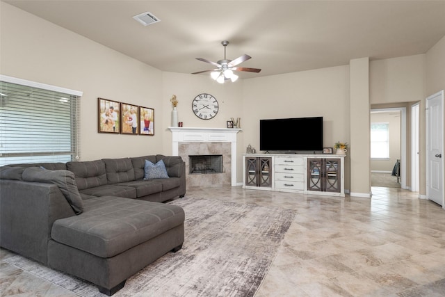 living room with ceiling fan and a tiled fireplace