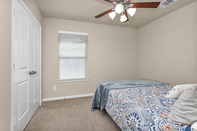 carpeted bedroom with ceiling fan and a closet