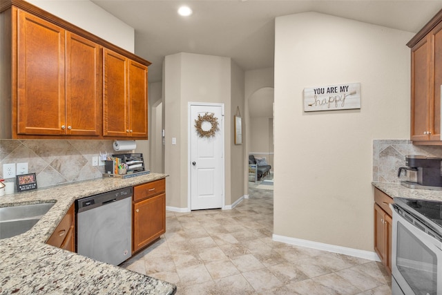 kitchen featuring dishwasher, stove, light stone countertops, and backsplash