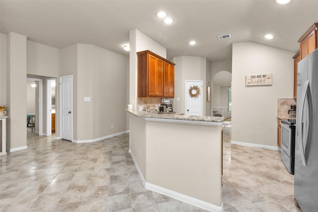 kitchen featuring backsplash, kitchen peninsula, light stone counters, and stainless steel appliances