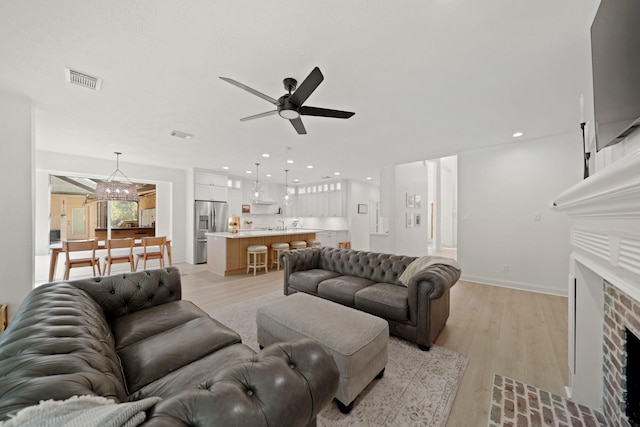 living room featuring ceiling fan and light wood-type flooring