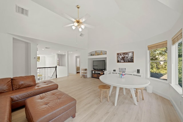 living room with light hardwood / wood-style flooring, high vaulted ceiling, and ceiling fan