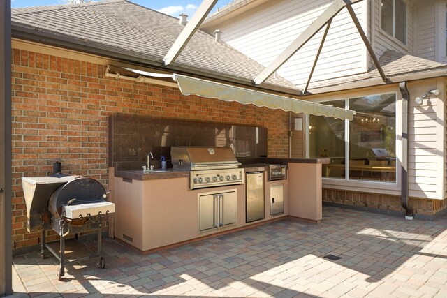 view of patio featuring area for grilling, sink, and grilling area