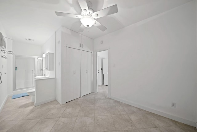 unfurnished bedroom with ceiling fan, ensuite bath, a closet, and light tile patterned floors